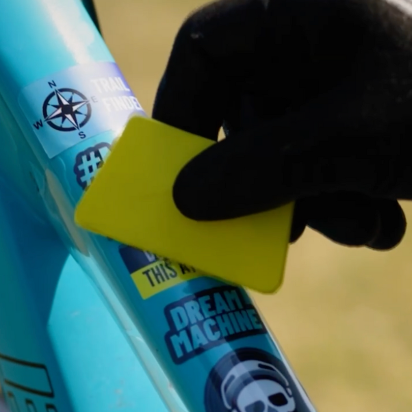 clear frame protector being installed on a blue cycle