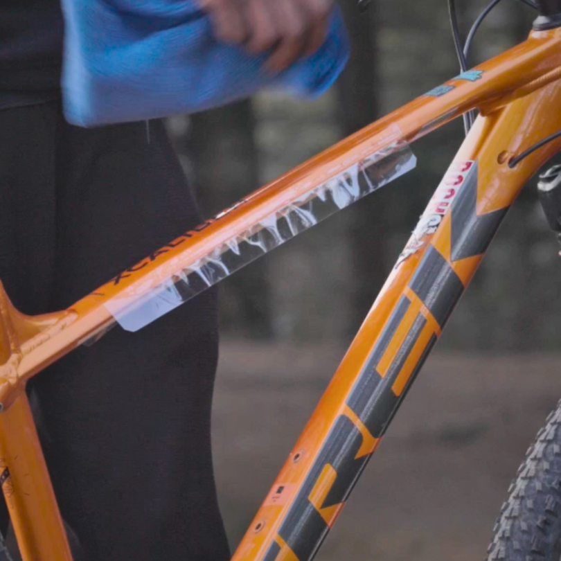 orange cycle with clear frame protector being installed