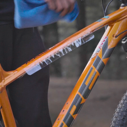 orange cycle with clear frame protector being installed